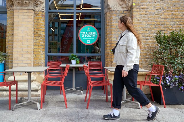 Woman walking down the street looking into a restaurant window